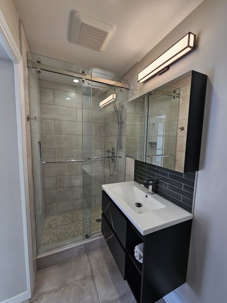 The renovated washroom now boasts a stunning new shower with state-of-the-art fixtures and a streamlined design. The space has been carefully crafted to provide both visual appeal and enhanced functionality, making it a luxurious retreat for daily use. The transformation not only resolved the previous issues but also elevated the overall style of the main floor washroom, reflecting our commitment to quality and diligence. The result is a beautifully modern washroom that perfectly aligns with the clients' vision and enhances their home experience.
